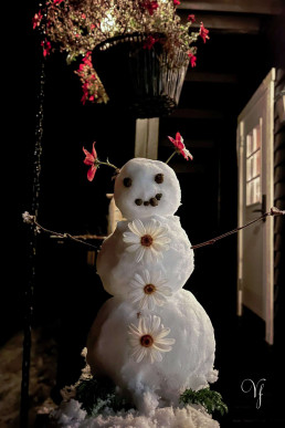 a snowman with flowers on it