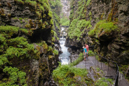 a couple of people standing on a bridge over a river